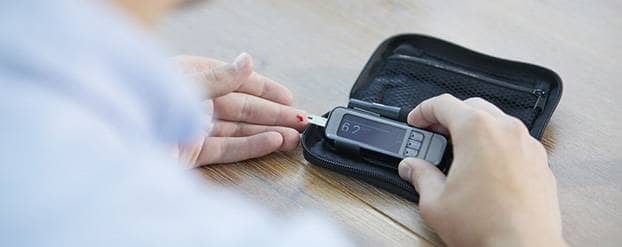 Iemand met diabetes checkt zijn of haar bloedsuiker