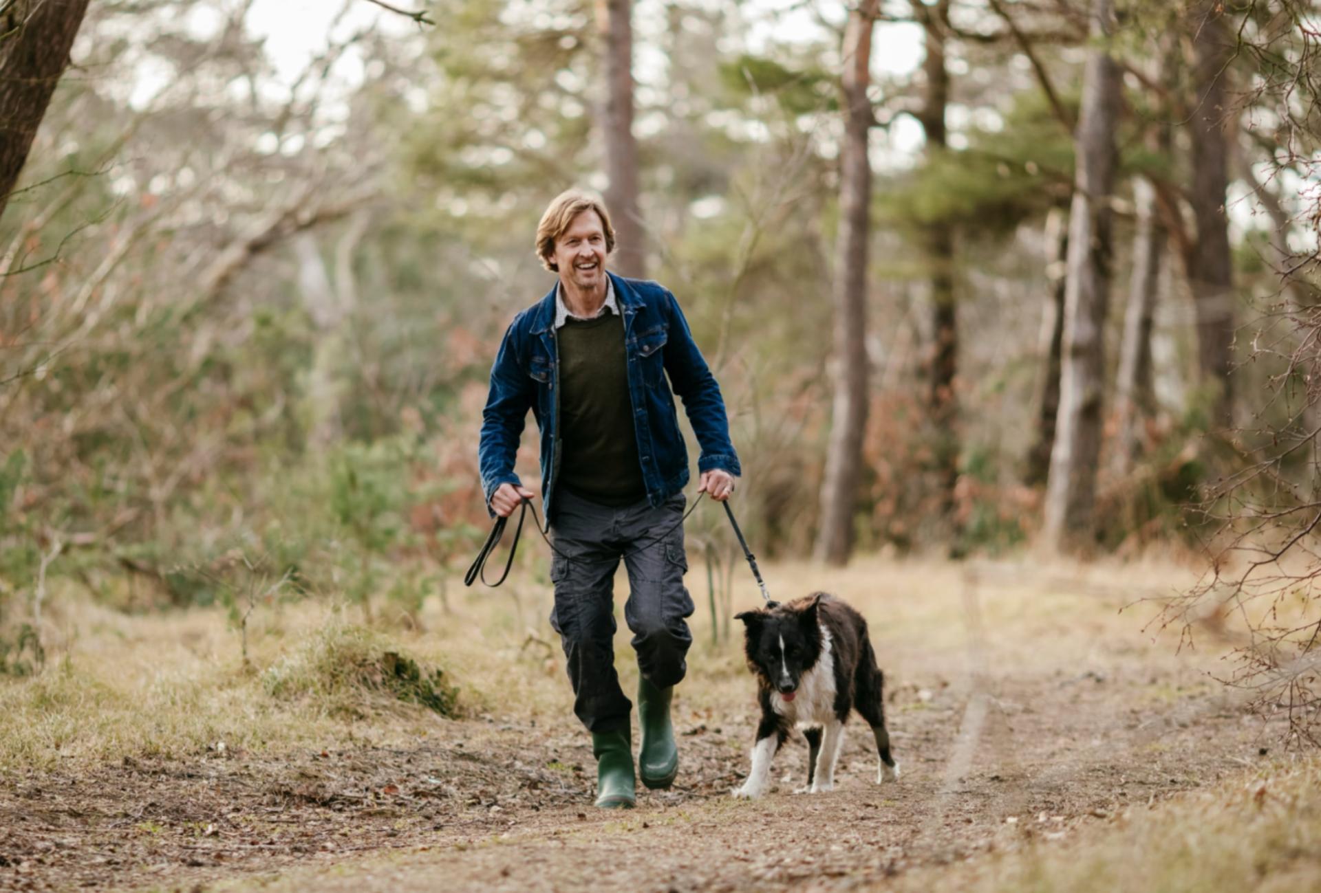 Man en hond wandelen in het bos